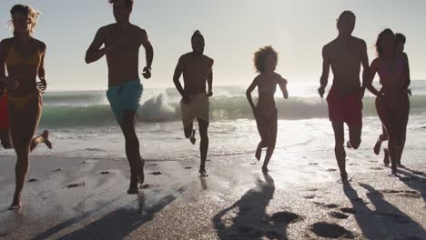 friends running side by side at beach