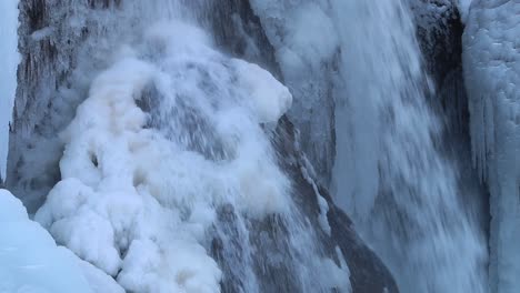 Cascada-Helgufoss-En-Primer-Plano-A-Principios-De-Primavera-Con-Rocas-Cubiertas-De-Hielo