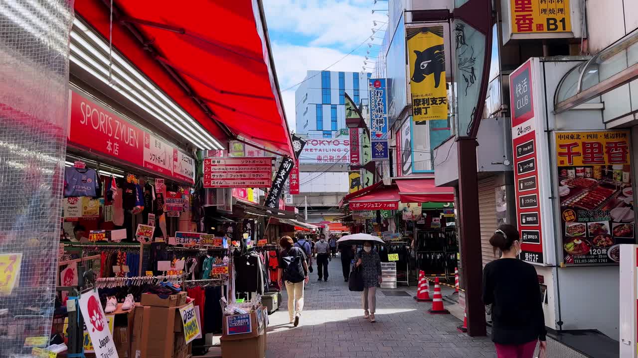 Bustling Japanese shopping street with colorful signs and pedestrians wearing masks