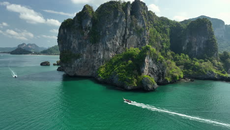 barco tradicional tailandés de cola larga conduciendo a lo largo de la costa de railay a ao nang krabi, tailandia