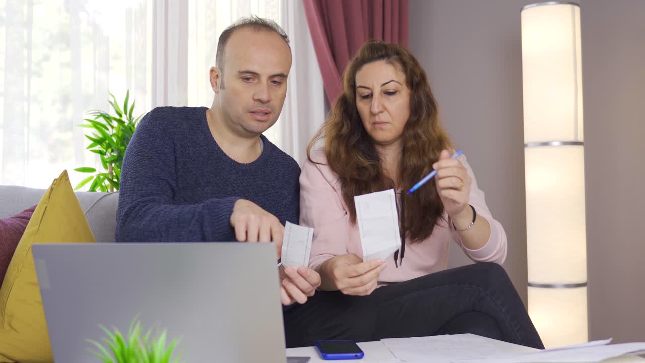 el marido y la esposa hacen cálculos, planean los gastos del presupuesto, discuten el dinero.