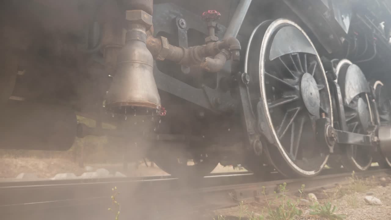 Vintage railway locomotive venting and dripping steam and water
