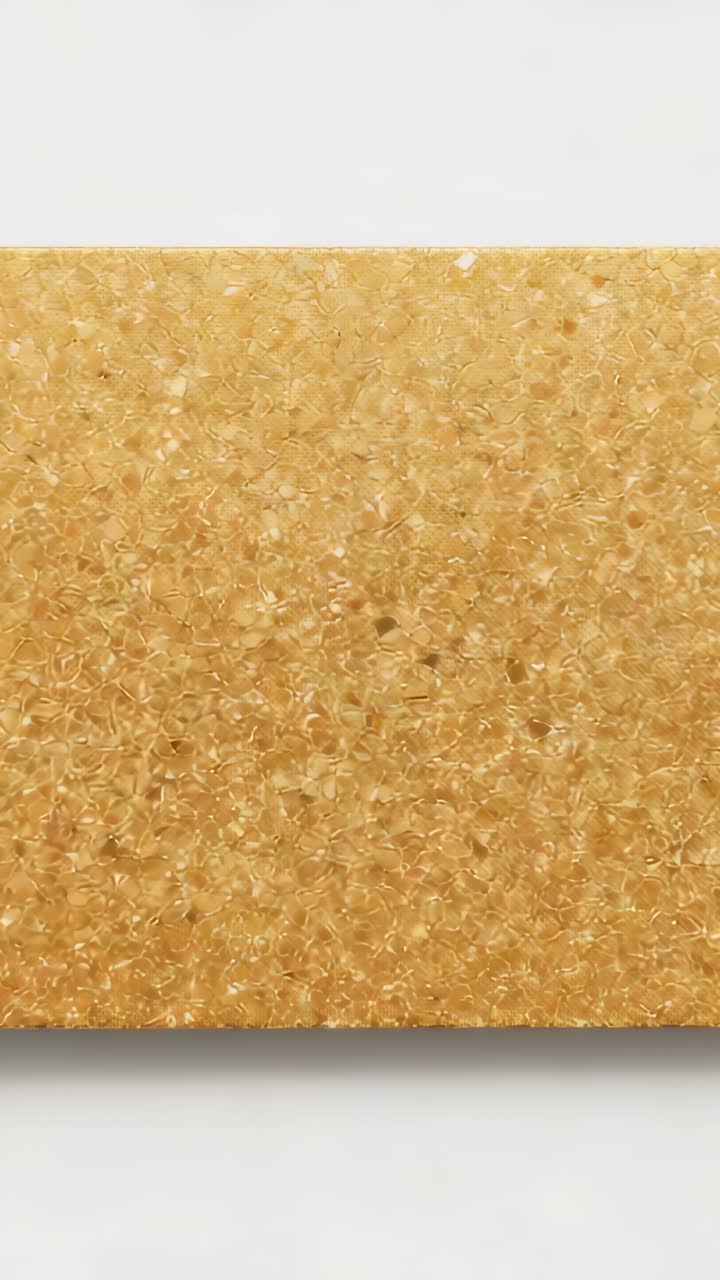 Vertical video: Shifting camera closer to golden textured panel on white wall, revealing flakes
