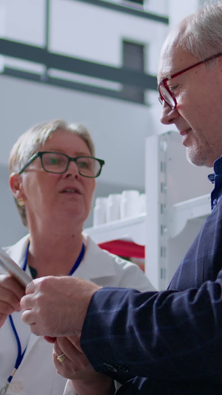 Video verticale: farmacista anziano che usa un termometro