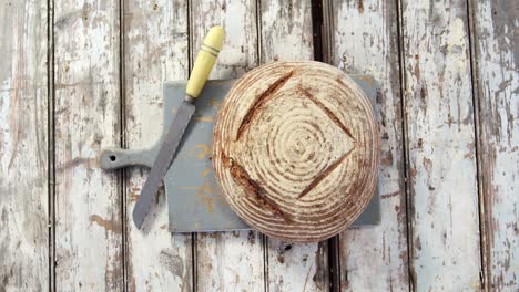 Hogaza-De-Pan-Con-Un-Cuchillo-Sobre-Una-Tabla-De-Cortar