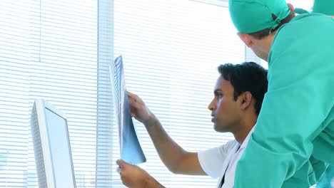 ángulo alto del equipo médico examinando una radiografía