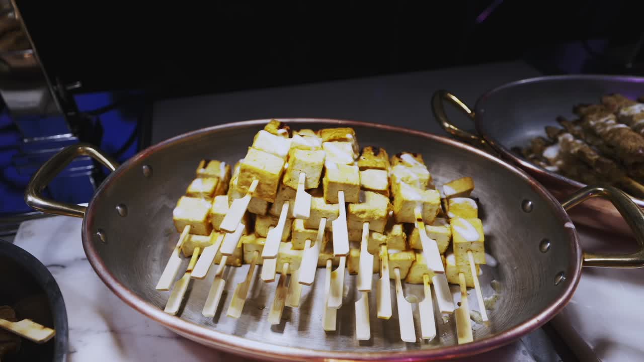 Deliziosi spiedini vegani di tofu che sfrigolano sulla griglia in una stazione alimentare