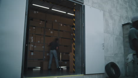 woman and man working in a warehouse, handling packages for delivery
