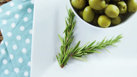 Green-olives-and-rosemary-herbs-on-table