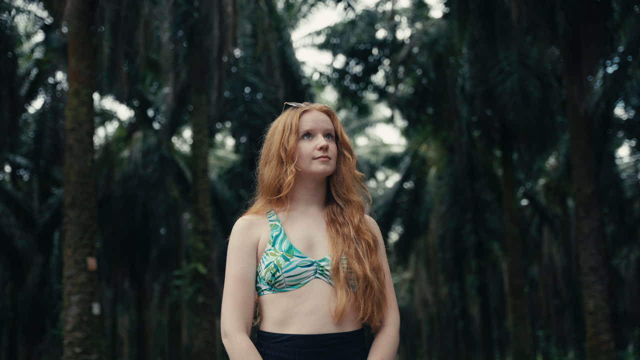 Redhead Woman in Bikini Top Among Palm Trees