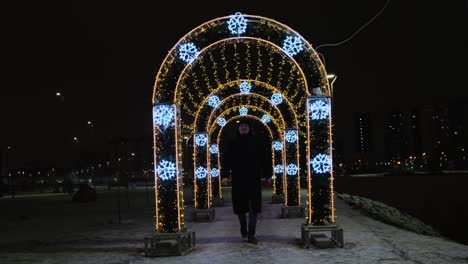 caminata nocturna de invierno a través de un arco iluminado