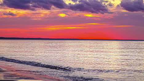 timelapse of ocean waves crashing onto a sand beach at sunset