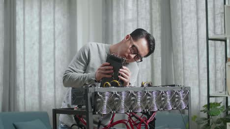 hombre asiático con gafas construye la plataforma de minería para la minería de criptomonedas