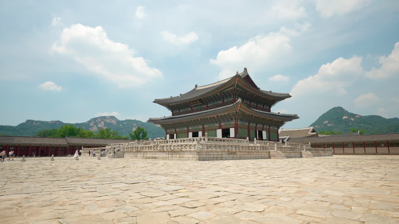 palacio gyeongbokgung contra las montañas bukhansan y nubes esponjosas flotantes - plano estático amplio