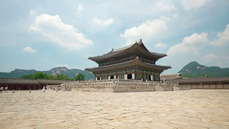 gyeongbokgung palace against bukhansan mountains and floating fluffy clouds - wide static shot