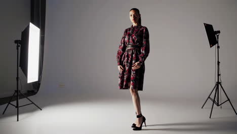 woman in floral dress taking selfie in studio