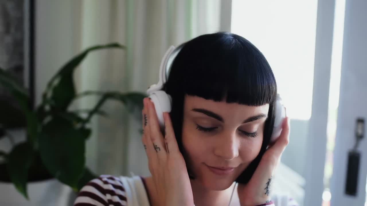 mujer escuchando música en casa 4k