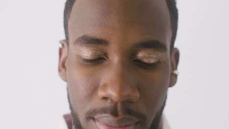 primer plano de un hombre guapo con maquillaje mirando a la cámara