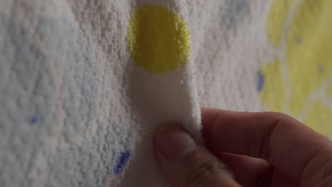 close-up of hand gently touching a textured towel for asmr