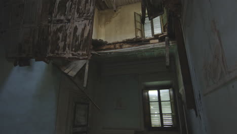 old abandoned building with collapsed floor in italy. high angle, tilt-up shot