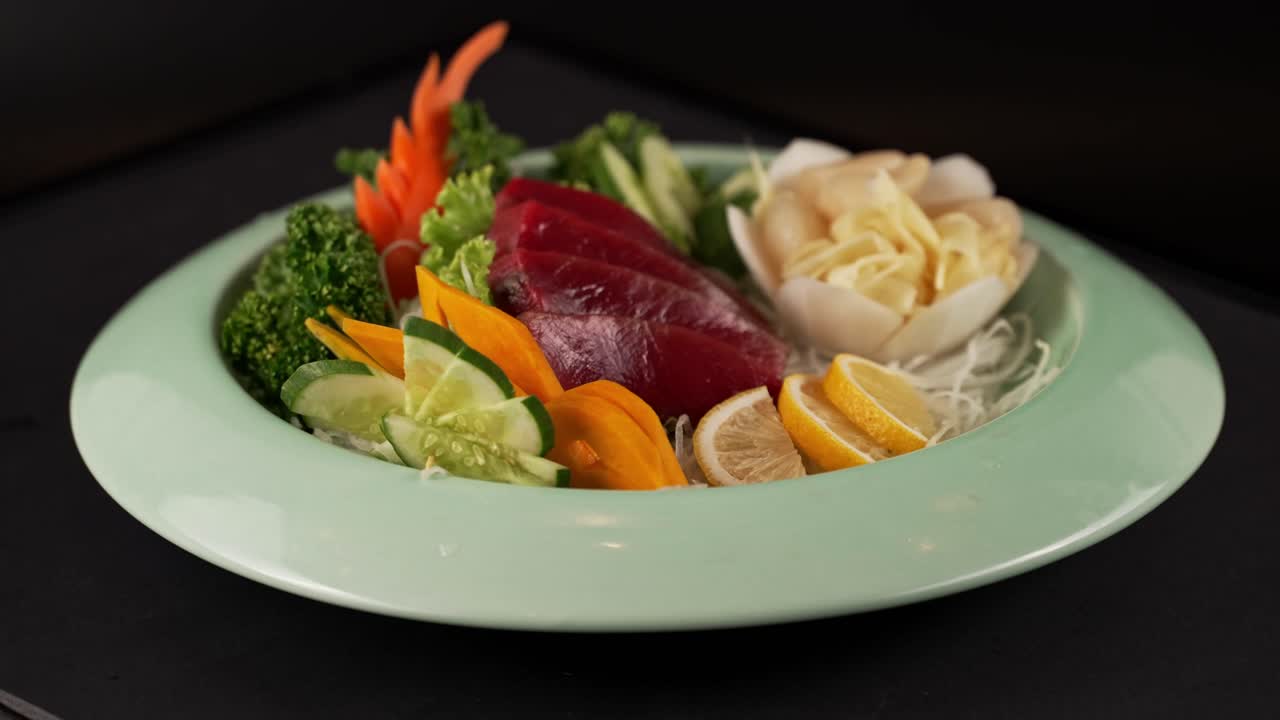 Delicate red fish sashimi with fresh vegetables, accented by ginger and lemon. 신선한 붉은 생선 사시미에 생강과 레몬이 더해진 한 접시.