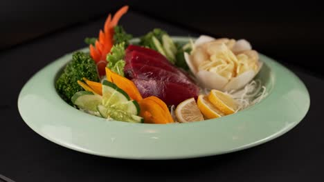 delicate red fish sashimi with fresh vegetables, accented by ginger and lemon. 신선한 붉은 생선 사시미에 생강과 레몬이 더해진 한 접시.