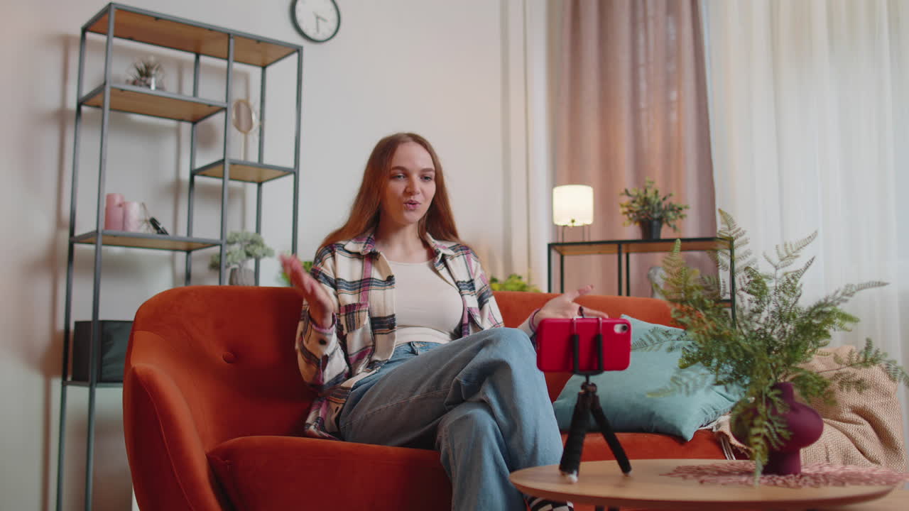 소녀 블로거 인플루언서가 스마트폰으로 셀카를 찍고, 집에서 온라인으로 가상 소셜 미디어 비디오를 만 ⁇ 니다.