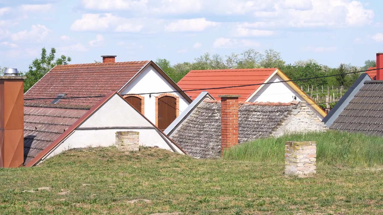Traditional wine cellars with unique architecture under a blue sky in a hungarian village