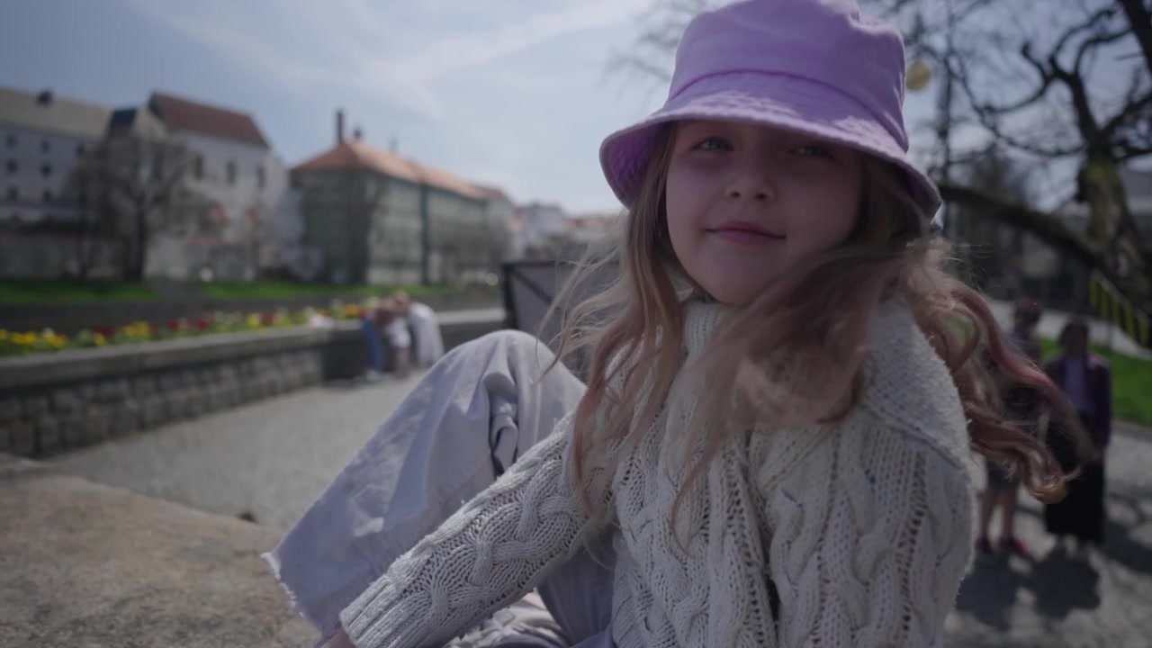 Ritratto di una ragazza che ha scalato la ringhiera in pietra del vecchio ponte e sorride felicemente nell'obiettivo della fotocamera