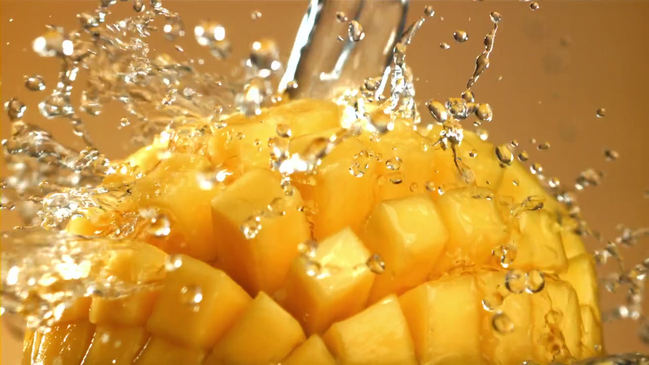 Schizzi d'acqua rinfrescante su un mango giallo a cubetti