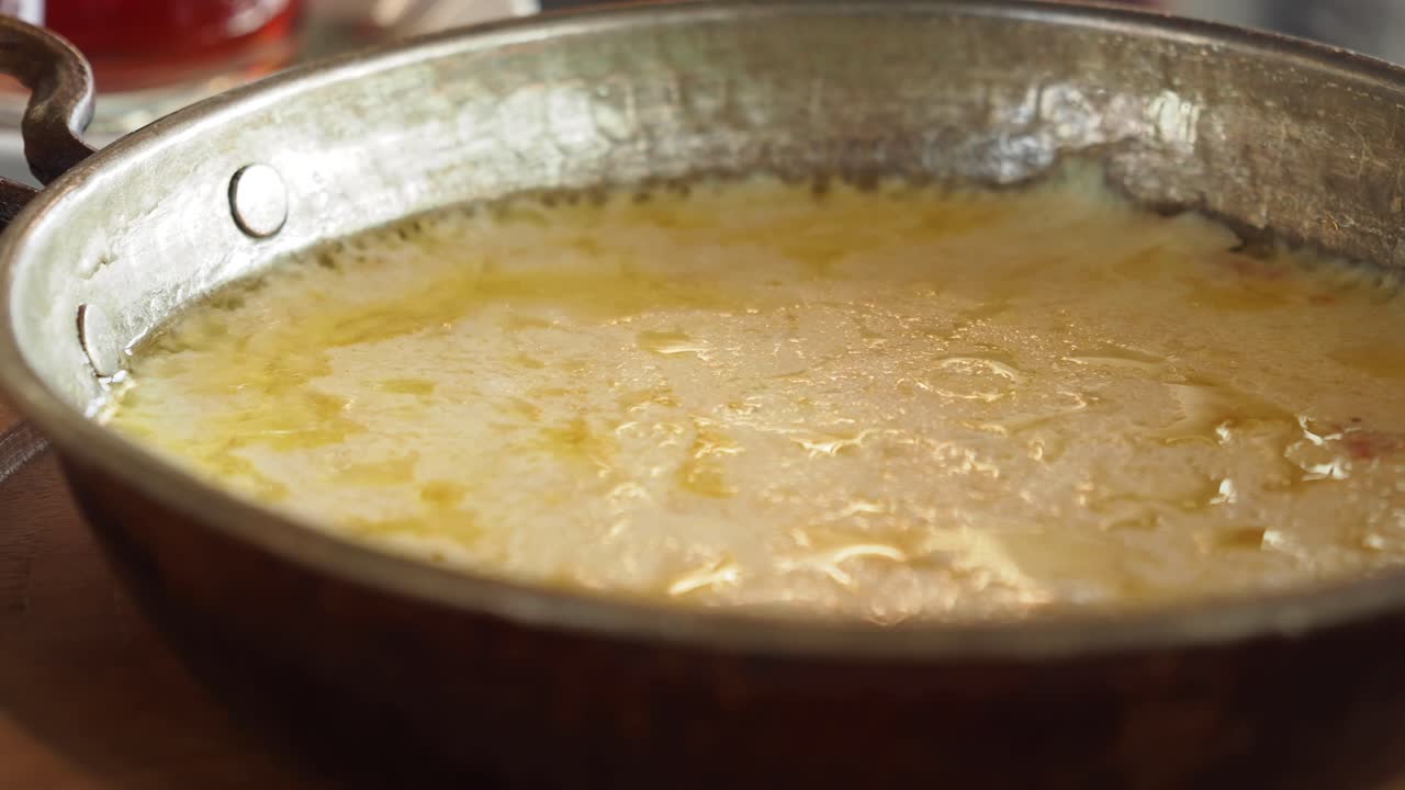 Formaggio fuso in una padella di rame