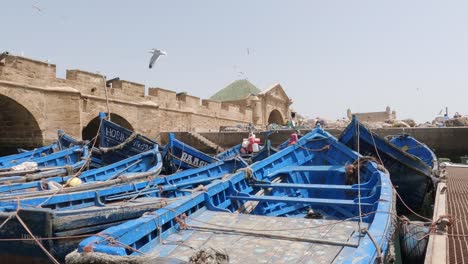 Among-the-iconic-blue-fishing-boats,-fortress,-and-seagulls-in-Essaouira,-Morocco