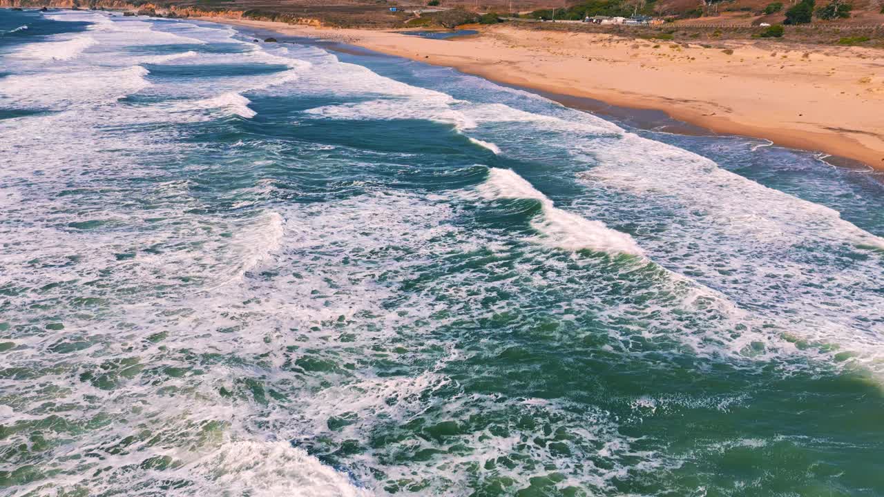 agua turquesa y olas costa costera en cámara lenta en la playa de arena en big sur, california