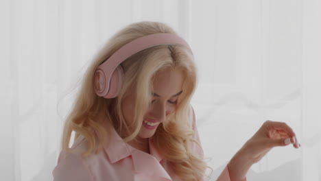 mujer disfrutando de la música en pijama rosa