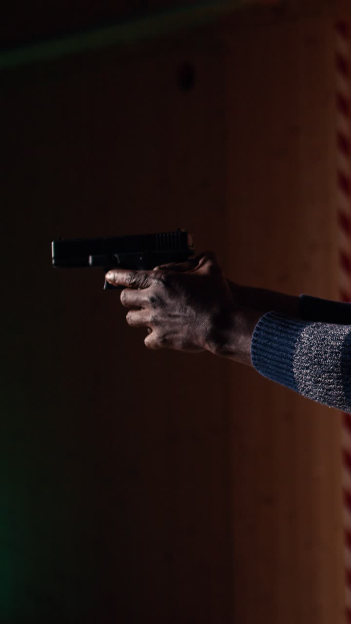 Vertical video Man reloading gun during firearm practice, pointing weapon