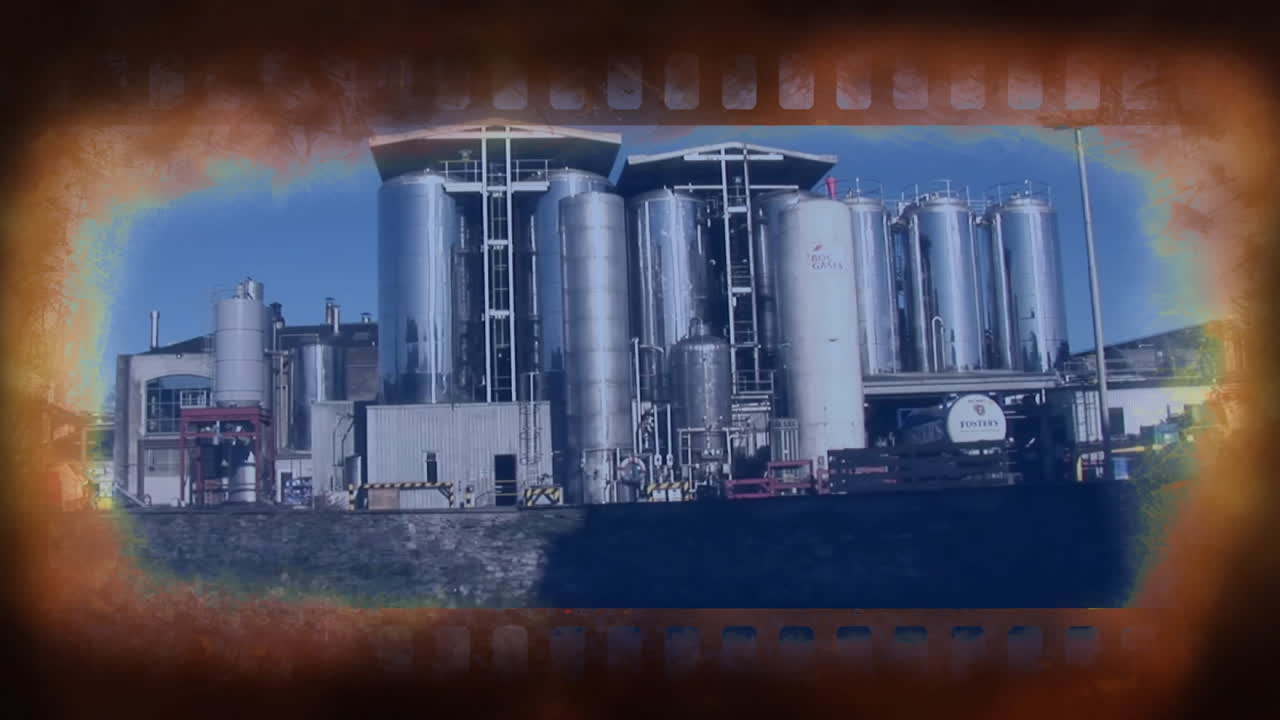Industrial factory with large metal tanks, film strip animation over scene