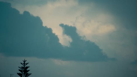 A-dramatic-time-lapse-of-a-sliding-clouds,-dark-blue-sky,-stormy-weather,-middle-east-Tel-Aviv,-Israel,-moving-tree,-Sony-4K-video