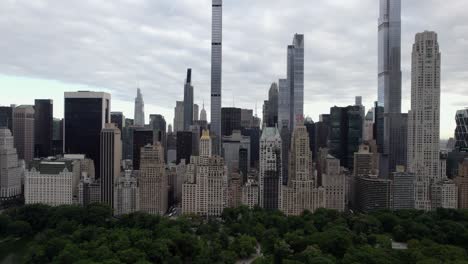 Vista-Aérea-Sobre-El-Parque-Central,-Hacia-Rascacielos-Súper-Altos-En-El-Centro-De-La-Ciudad,-Nueva-York,-Ee.uu.---Inclinación,-Disparo-De-Drones