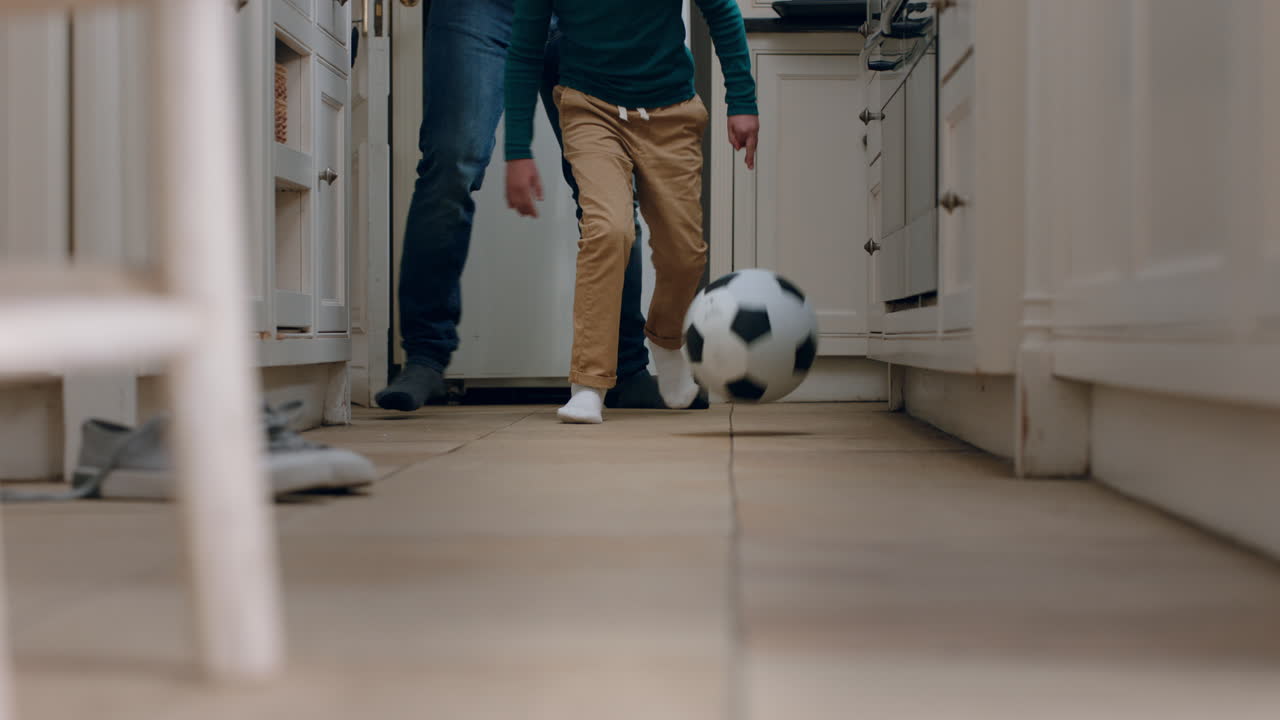 padre e hijo jugando al fútbol en la cocina pateando una pelota de fútbol niño disfrutando del juego con papá en casa