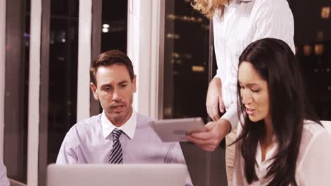 Businesswoman-discussing-with-colleagues-over-laptop