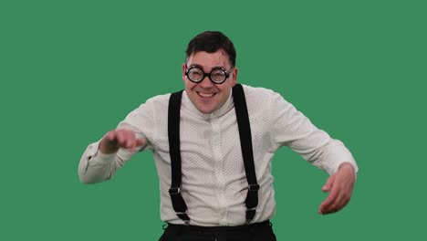 retrato de un hombre satisfecho bailando y aplaudiendo las manos. un hombre con una camisa blanca con tirantes y gafas con lentes gruesas posa en el estudio en una pantalla verde. cámara lenta. primer plano
