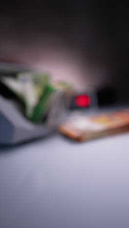 bank equipment works counting green banknotes. blurred image. male hand places euro bills at the foreground. vertical video.