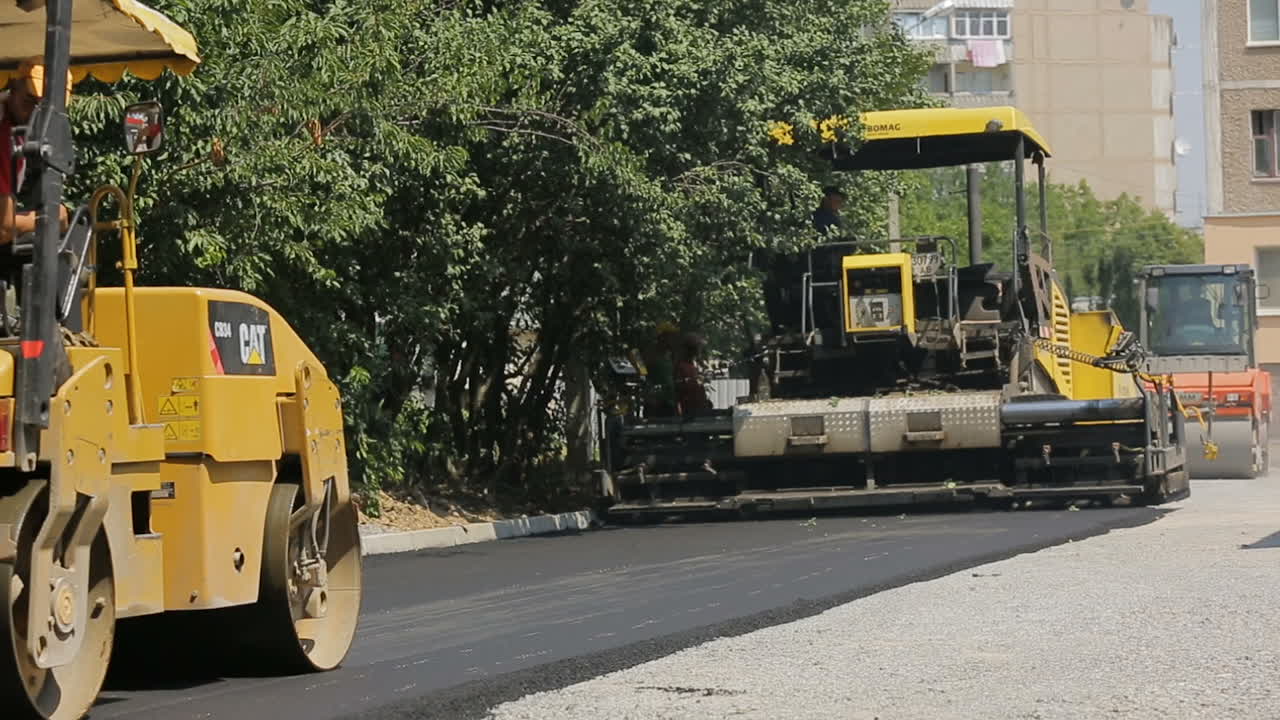 Making Asphalt On The Street. VINNITSA, UKRAINE - JULY 2017: Men working at the road construction