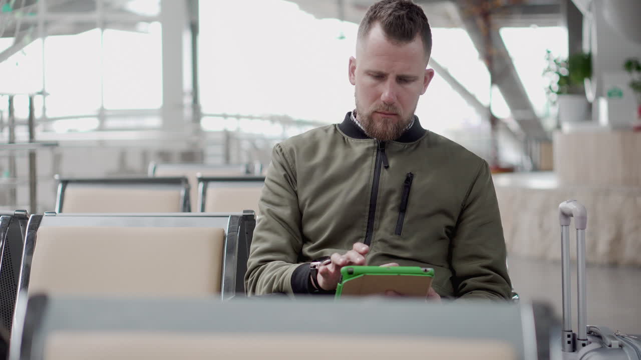 человек, использующий планшет в аэропорту