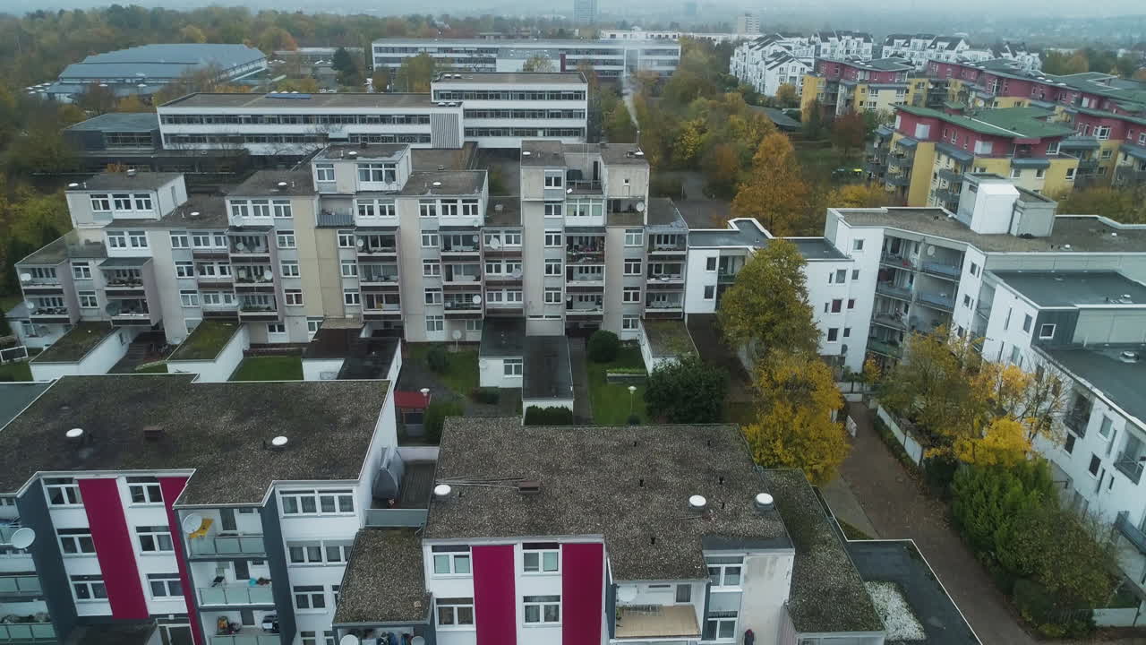 Drone s'élevant et s'inclinant vers le haut au-dessus de bâtiments résidentiels dans une Heidelberg brumeuse