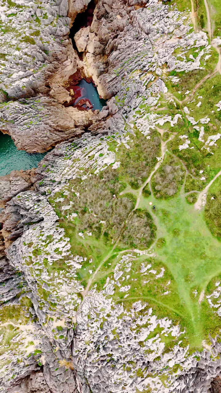 Ragged rocky shore of the sea or ocean. Rising above the spiky rocks at the coast of blue waterscape.