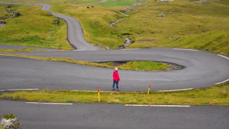 Mujer-En-El-Paso-De-Montaña-Nordradalsskard,-Islas-Feroe,-Levantando-Los-Brazos-Y-Admirando-El-Paisaje-Feroés