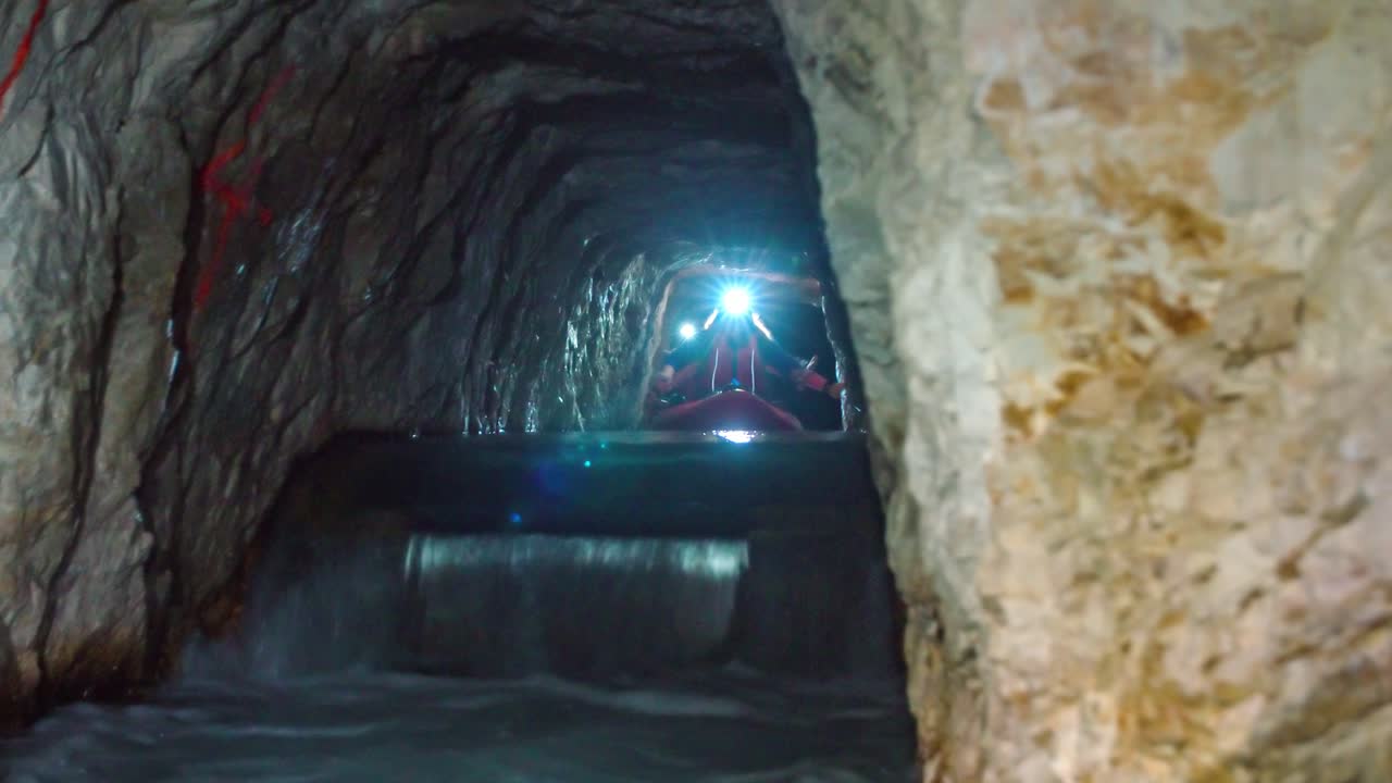 젊은 여성들이 지하 광산 카약 투어 중 급류를 경험해요
