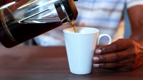 senior man pouring coffee in a mug
