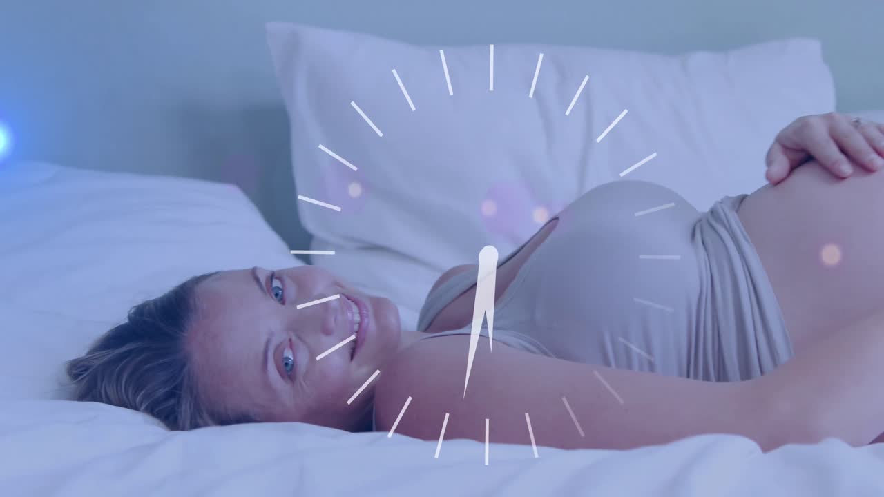 침대에 누워서 배를 문지르는 행복한 임신한 백인 여성